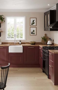 a kitchen with red cabinets and black appliances