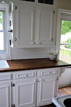 a kitchen with white cabinets and wood counter tops on pinter to see the details