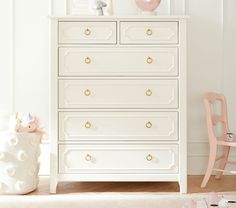 a white dresser sitting next to a baby's crib