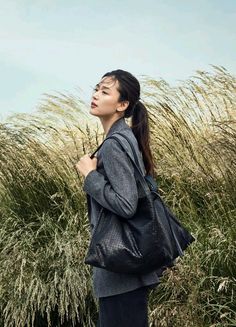 a woman standing in front of tall grass