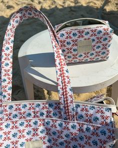 a white and red bag sitting on top of a chair next to a white table