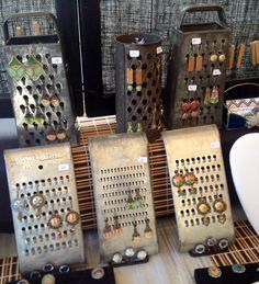 an assortment of decorative items on display in a store or showroom, including metal graters and vases