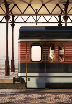 an old train car sitting on the tracks in front of a covered area with water