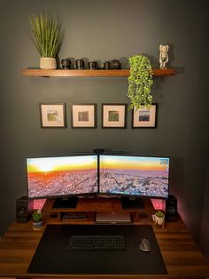 two computer monitors sitting on top of a wooden desk