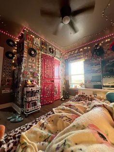 a bedroom decorated with lots of colorful lights and decorations on the walls, along with a bed covered in blankets