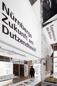 a man standing in front of a white sign that says nurbergs dukunt am guttendteich