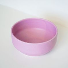 a pink bowl sitting on top of a white table