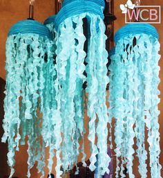 three blue jelly like lights hanging from the ceiling in front of a mirror with flowers on it