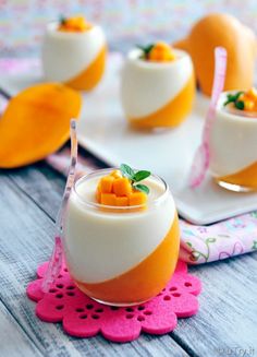 small desserts are arranged on trays with pink doily