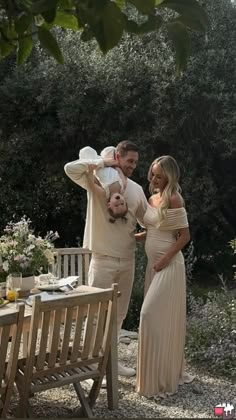 a man and woman standing next to each other near a table