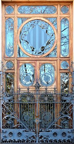 an ornate wooden door with glass panels and wrought iron bars on the front entrance to a building