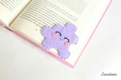 an open book with a purple teddy bear on it