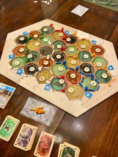 a board game is shown on the table with cards and token pieces scattered about it