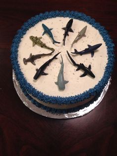 a blue and white cake topped with lots of fake sharks