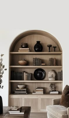 a living room filled with furniture and bookshelves next to a wall mounted shelf