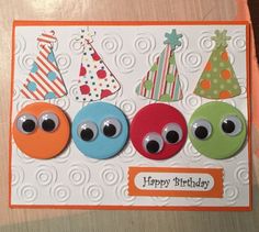 a birthday card with three different colored buttons and one has an eyeball on it