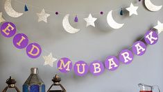 a purple table topped with lots of food next to lanterns and stars hanging from the ceiling