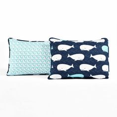 two blue and white pillows sitting next to each other