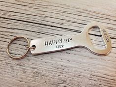 a personalized bottle opener keychain with the words happy birthday alex engraved on it