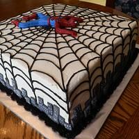 a spiderman cake on a wooden table