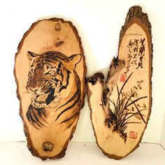 two pieces of wood that have been carved to look like tigers and grass on them