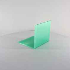 a green piece of glass sitting on top of a white table