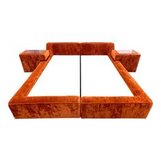 an orange couch with two end tables on it