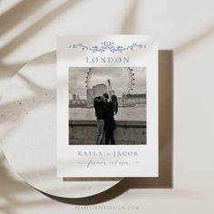 a couple standing next to each other in front of a ferris wheel with the london eye on it