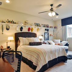 a bedroom with two beds and a desk in front of the bed is full of pictures on the wall