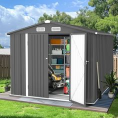 an outdoor storage shed with its doors open and tools in the yard next to it