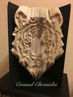 an intricate book sculpture made from folded books