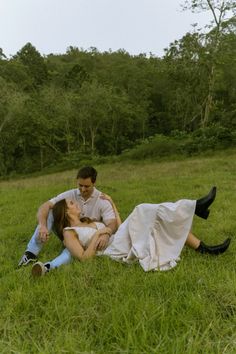 a man and woman laying in the grass