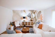 a living room filled with furniture and a painting on the wall behind it's couches