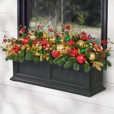 a window box filled with christmas decorations and greenery