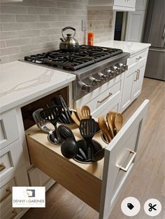 an open drawer in the middle of a kitchen filled with utensils