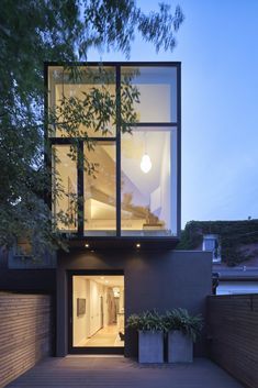 a modern house with large windows and wooden decking on the side of the building