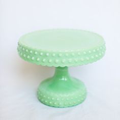 a green cake stand with polka dots on it