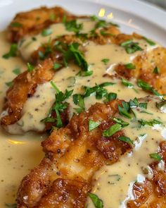 chicken with gravy and parmesan sauce on a white plate, ready to be eaten