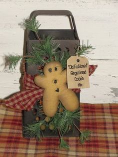 an old fashioned christmas ornament with a teddy bear and pine needles on it