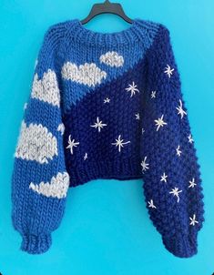 a blue sweater with white stars and clouds on it