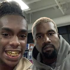 two men with gold teeth standing next to each other