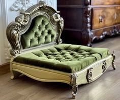 an antique style bed with green velvet upholstered