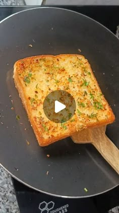 a piece of bread is being cooked in a pan with a wooden spatula on it