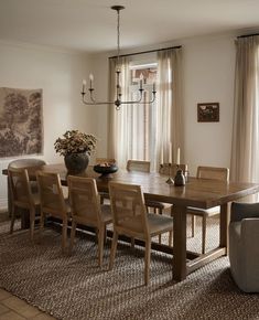 a dining room table and chairs in front of a window