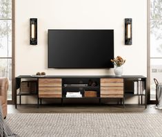 a large flat screen tv mounted to the side of a wooden entertainment center in a living room