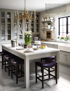 a large kitchen with an island in the middle and two chairs at the end,