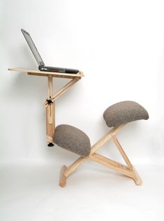 a chair with a laptop on top of it and a wooden stand attached to the back