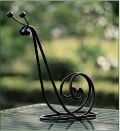 a metal object sitting on top of a glass table with trees in the back ground