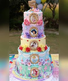 a multi - tiered cake is decorated with princesses and other things on it