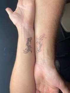 two people are holding hands with tattoos on their arms and one has a horse tattoo on his arm